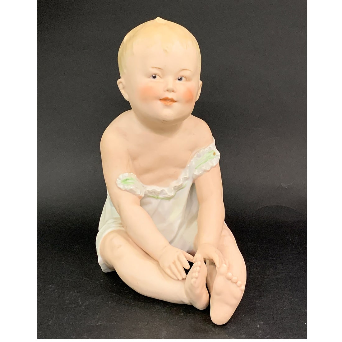 Vintage Gebruder Heubach Porcelain Piano Baby: Vintage Gebruder Heubach Porcelain Piano Baby Figurine From Germany Featuring A Sitting Boy In A White Nightshirt With Green Trim.Bears Mark On Backside8 1/4" Tall