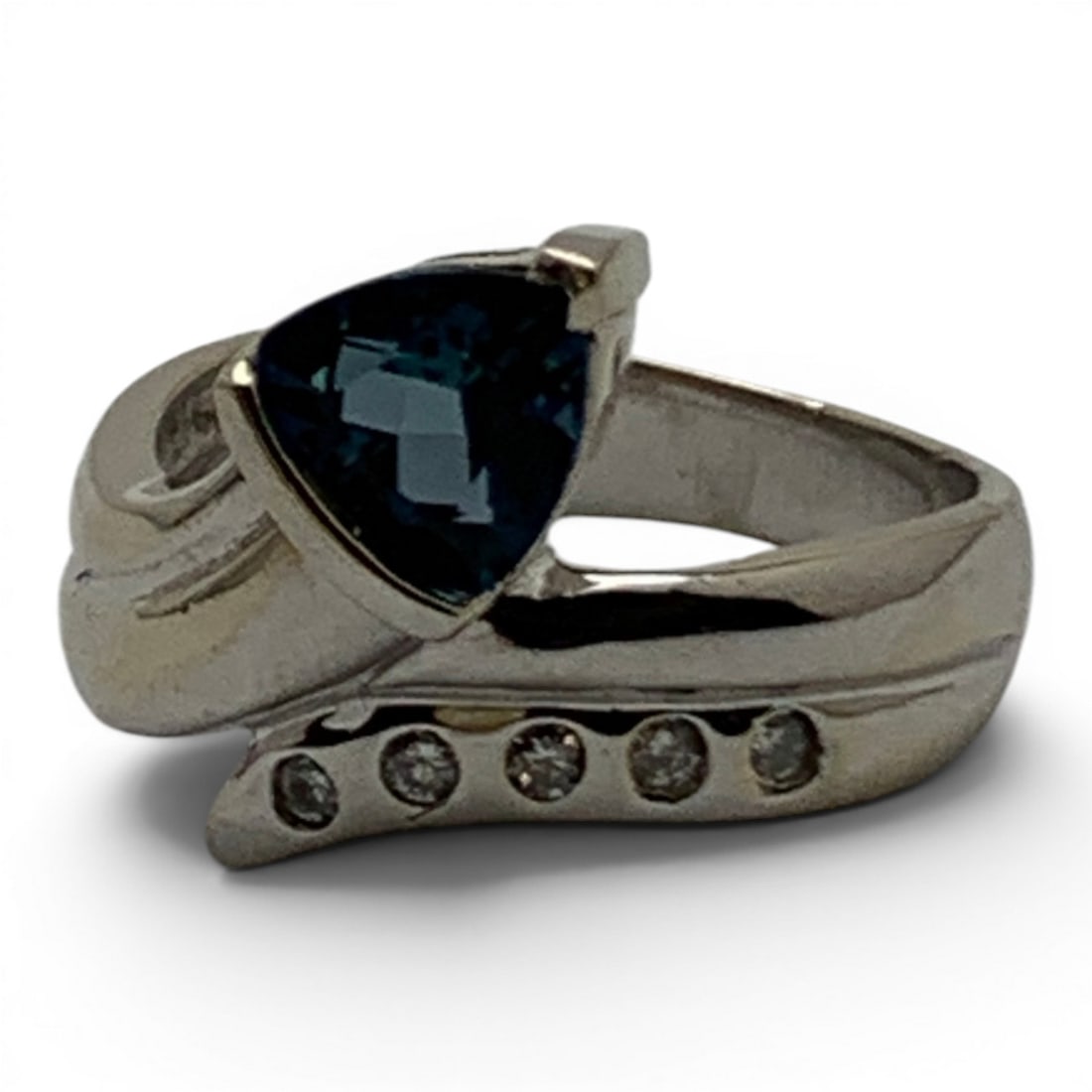 14k White Gold Diamond & Blue Topaz Ring: 14k White Gold Ring With A Bypass Design Featuring A Prominent Triangle Cut Blue Topaz Gemstone & 5 Round Cut Earth Mined Diamonds Approx. 0.025ct Each.Marked 14k - Size 7.75 - 4.4 DwtGemstones