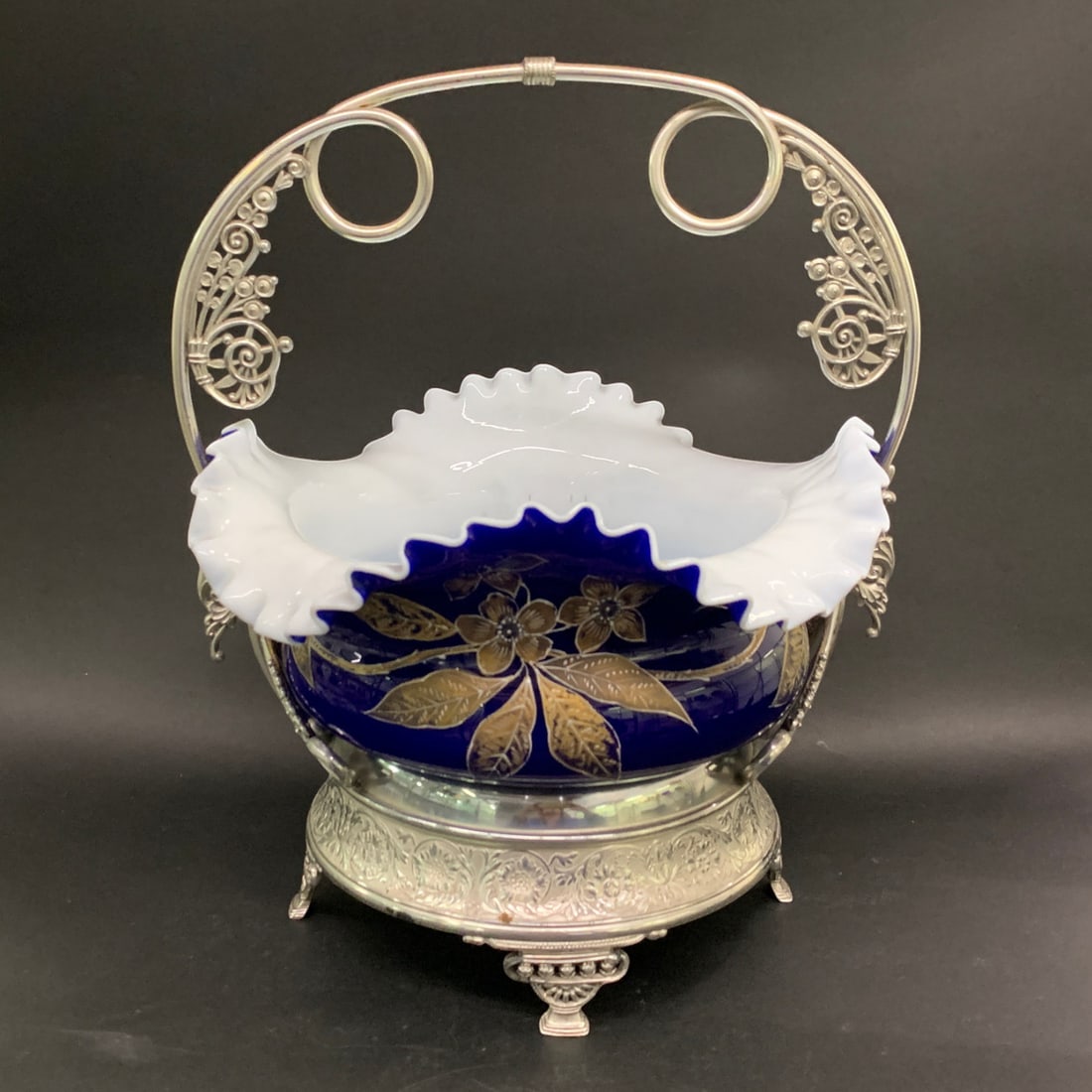 Meriden B. Silver Plate Centerpiece Basket: Meriden B. Quadruple Silver Plate Centerpiece Basket Featuring A Cobalt Blue Glass Bowl With A White Cased Interior And A Ruffled Edge And A Silver Plated Metal Stand.Marked On Bottom: Meriden B. Comp