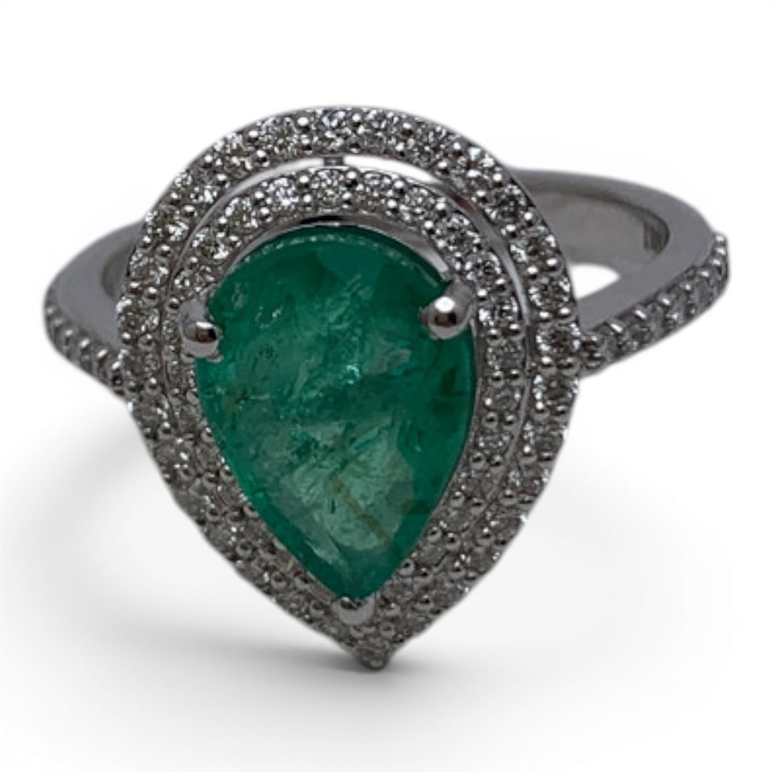 18k White Gold Diamond & Emerald Ring: 18k White Gold Ring Featuring 1 Prominent Tear Drop Cut Green Emerald Gemstone Surrounded By 72 Round Cut Diamonds Approx. 0.014ct Each.Marked: 18k - Size 7 - 2.6