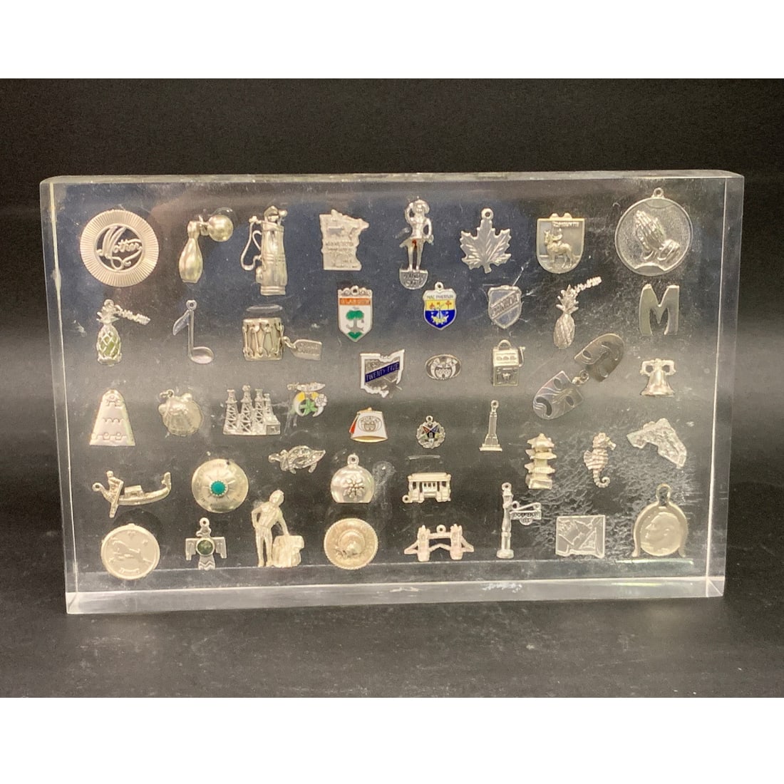 Collection Of 44 Sterling Charms In Lucite Casing: Collection Of 44 Sterling Charms In Lucite Casing 8 3/4" X 5 5/8"