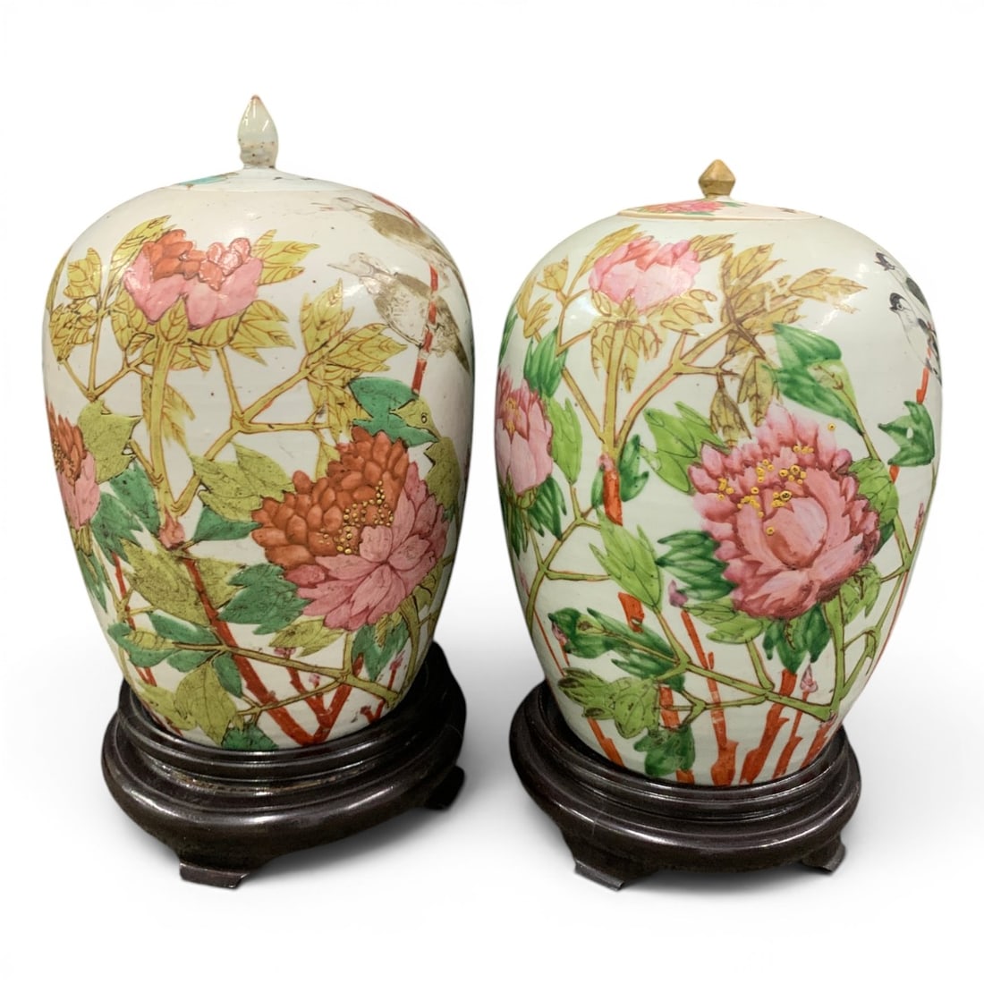 Pair Of Porcelain Famille Rose Enamel Lidded Vases: Pair Of Porcelain Famille Rose Enamel Lidded Vases Featuring Birds Perched On Branches With Pink Peonies And Green Foliage Both Sat On Wooden Bases15 3/4" & 14 1/4" Tall