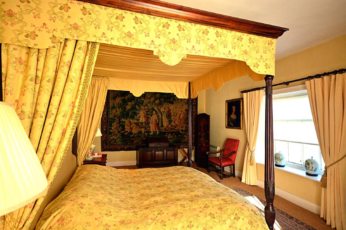 A George III style mahogany four poster bed: A George III style mahogany four poster bed, made by master craftsman Adam Bunning of Bridgnorth, the moulded ogive cornice above two original George III reeded and wheat ear carved pilasters joined t