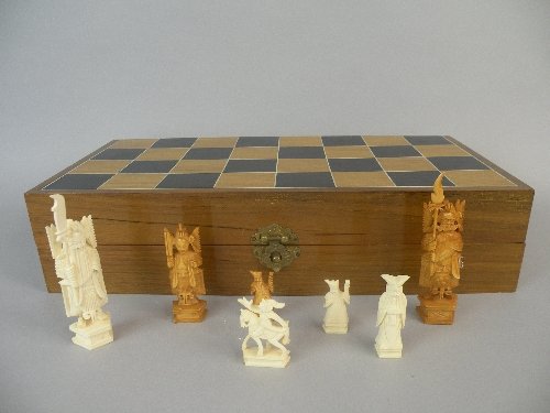 Halls Summer Collective Auction 21st August: A Chinese ivory chess set, circa 1930, the realistically carved ivory figures housed in a blue velvet fitted box with hinge, outer case painted as a chess board, figures: 5cm-13cm high, box: 43.5cm lo