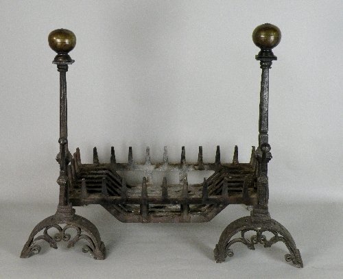 A near pair of Gothic Revival andirons with spit hooks : A near pair of Gothic Revival andirons with spit hooks supporting a fire basket, fire basket 68cm high, 60cm wide Provenance: From The Edward V. Phillips Collection