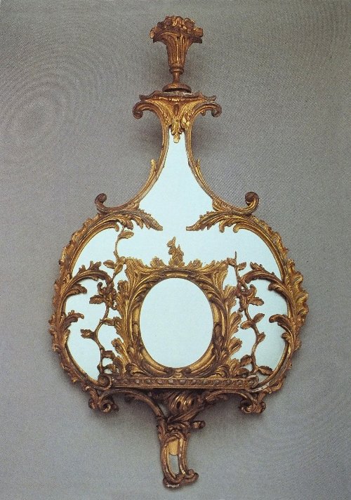 A George III giltwood mirrored wall bracket in the mann: A George III giltwood mirrored wall bracket in the manner of Thomas Chippendale, the urn pediment over a mirrored back in the form of a pear, carved with scrolling leaves over a rectangular gadrooned