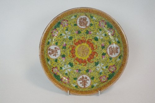 A Chinese famille jaunes saucer dish, Guangxu mark,: A Chinese famille jaunes saucer dish, Guangxu mark, decorated with a shou character within iron red and floral borders spaced by four characters meaning fortune and longevity and a geometric thunder s