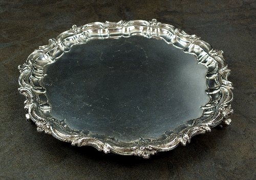 An Edwardian silver salver, W & C Sissons, London 1905,: An Edwardian silver salver, W & C Sissons, London 1905, of plain polished circular form with pie crust rim with scroll border, all raised on three scroll feet, 25cm diameter, weight 18oz
