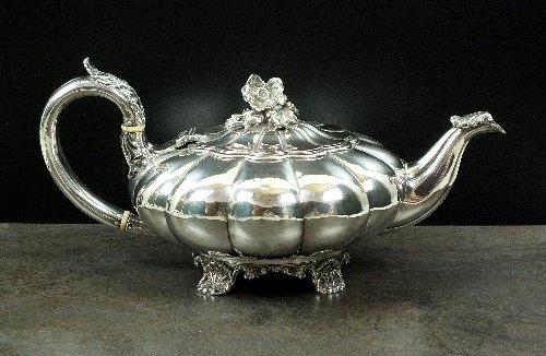 A William IV melon shaped silver teapot, Robert Hennell: A William IV melon shaped silver teapot, Robert Hennell II, London 1831, with acanthus leaf capped scroll handle with ivory dividers, with cast floral finial and raised on four scroll bracket feet, 12