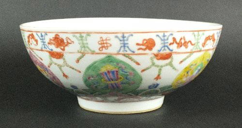 A Chinese 'clobbered' porcelain bowl, 20th century, the: A Chinese 'clobbered' porcelain bowl, 20th century, the exterior decorated in the famille rose palette with auspicious symbols and seated deities, the interior with a stylised flower motif, the base