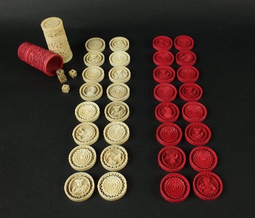 A set of Chinese Canton export ivory gaming counters,: A set of Chinese Canton export ivory gaming counters, mid-19th century, comprising thirty-two circular counters, sixteen stained red, each carved in relief with a flower to one side and a figural or a