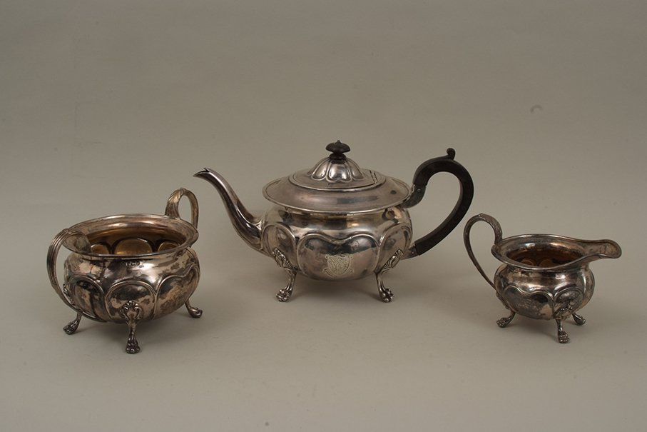 An Edwardian three piece silver teaset of moulded: An Edwardian three piece silver teaset of moulded circular form raised on four paw feet, inscribed and with armorial, by Martin Hall & Co, Sheffield 1905, 38.5oz.