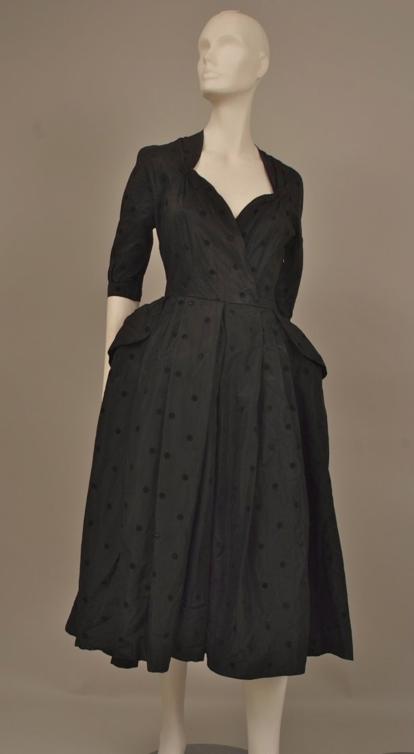 1950's 'Harald', Curzon St, London W1. Couture black: 1950's 'Harald', Curzon St, London W1. Couture black rayon cocktail dress, with layers of petticoats, nipped waist, side pockets and side metal zipper. (There is slight iron burn damage and a small ho