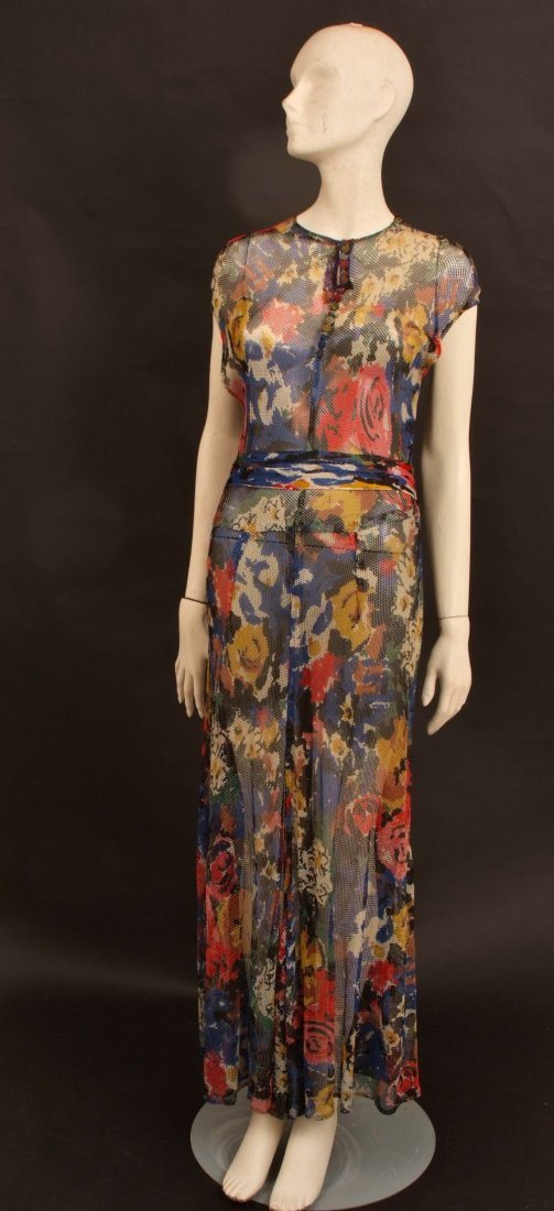 1930's Evening Dress. The fabric has been cut on the: 1930's Evening Dress. The fabric has been cut on the bias and patterned to create a figure hugging elegant dress. The floral print on a heavy net fabric has pretty original buttons at the neck line. T