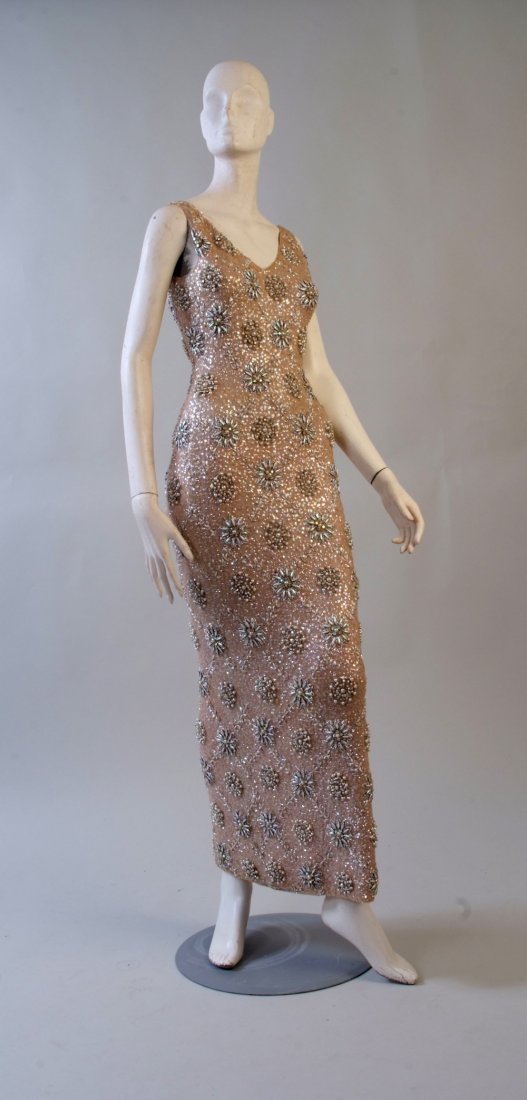 A 1960's Hand Beaded Wool Knitted Dress. The dress is: A 1960's Hand Beaded Wool Knitted Dress. The dress is finely knitted from very soft wool and covered in sequins, pearls, diamante and beads lovingly hand sewn. Very heavy vintage dress, beautifully fi