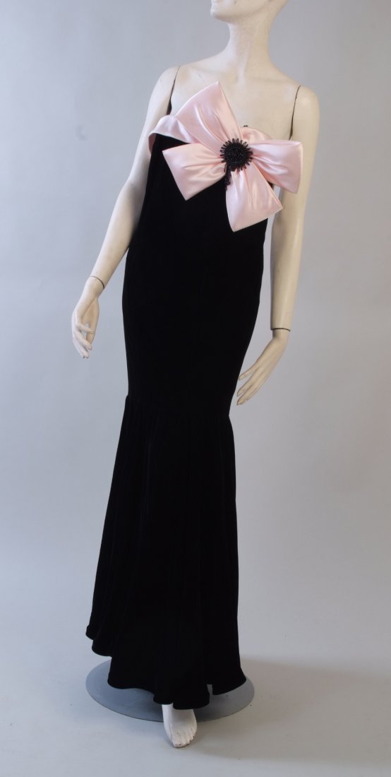 A 'Murray Arbeid' Couture Evening Dress. Made in: A 'Murray Arbeid' Couture Evening Dress. Made in London for Neiman Marcus. Black silk velvet, with boned fitted strapless bodice, low back with back zip and fasteners. Beautiful soft pink satin bow de