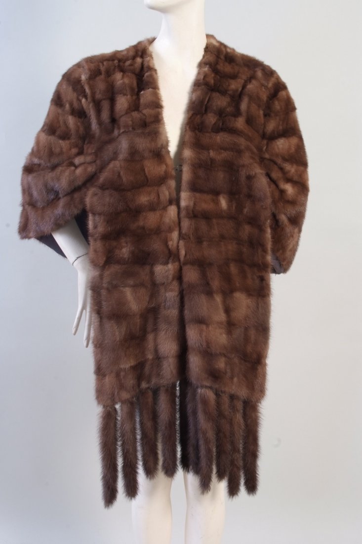 A Vintage Mink Cape. This beautiful mink cape is a: A Vintage Mink Cape. This beautiful mink cape is a cross between silver and brown. A beautiful front fastened with metal clips, with tails hanging from the front. The shoulders are gathered and fall g