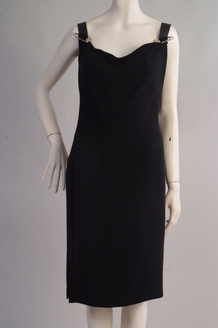 A 'Gianni Versace Couture' Dress. Black cocktail: A 'Gianni Versace Couture' Dress. Black cocktail dress with the4 Versace Safety Pin. Inner structured under garment. Elastic shoulder straps. Scooped back and opening at the hem. Size 42. (1)