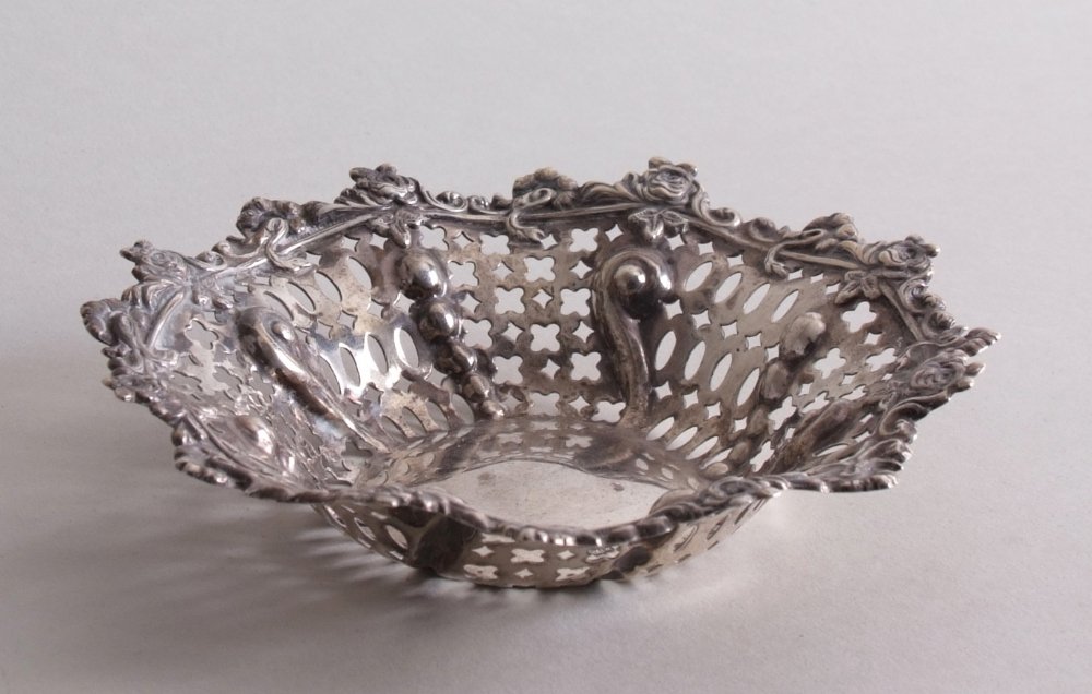An Edwardian silver bon bon dish, by Mappin & Webb,: An Edwardian silver bon bon dish, by Mappin & Webb, Sheffield 1903, foliate-scroll border in relief, over pierced body, 16cmW, 141g