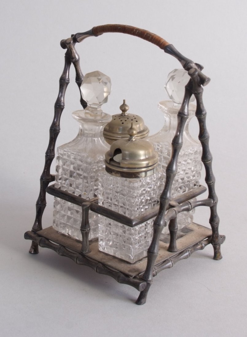 Victorian silver plated four piece condiment set in the: Victorian silver plated four piece condiment set in the manner of Christopher Dresser, by James Dixon and Sons, Sheffield, the faux bamboo 'A' shaped frame containing four cut glass bottles, 18cm
