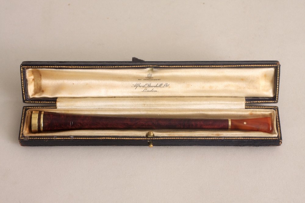 An early 20th century Alfred Dunhill cigarette holder,: An early 20th century Alfred Dunhill cigarette holder, trumpet form, with amber mouth piece and 14ct gold tip, in its tooled leather case, 15cm