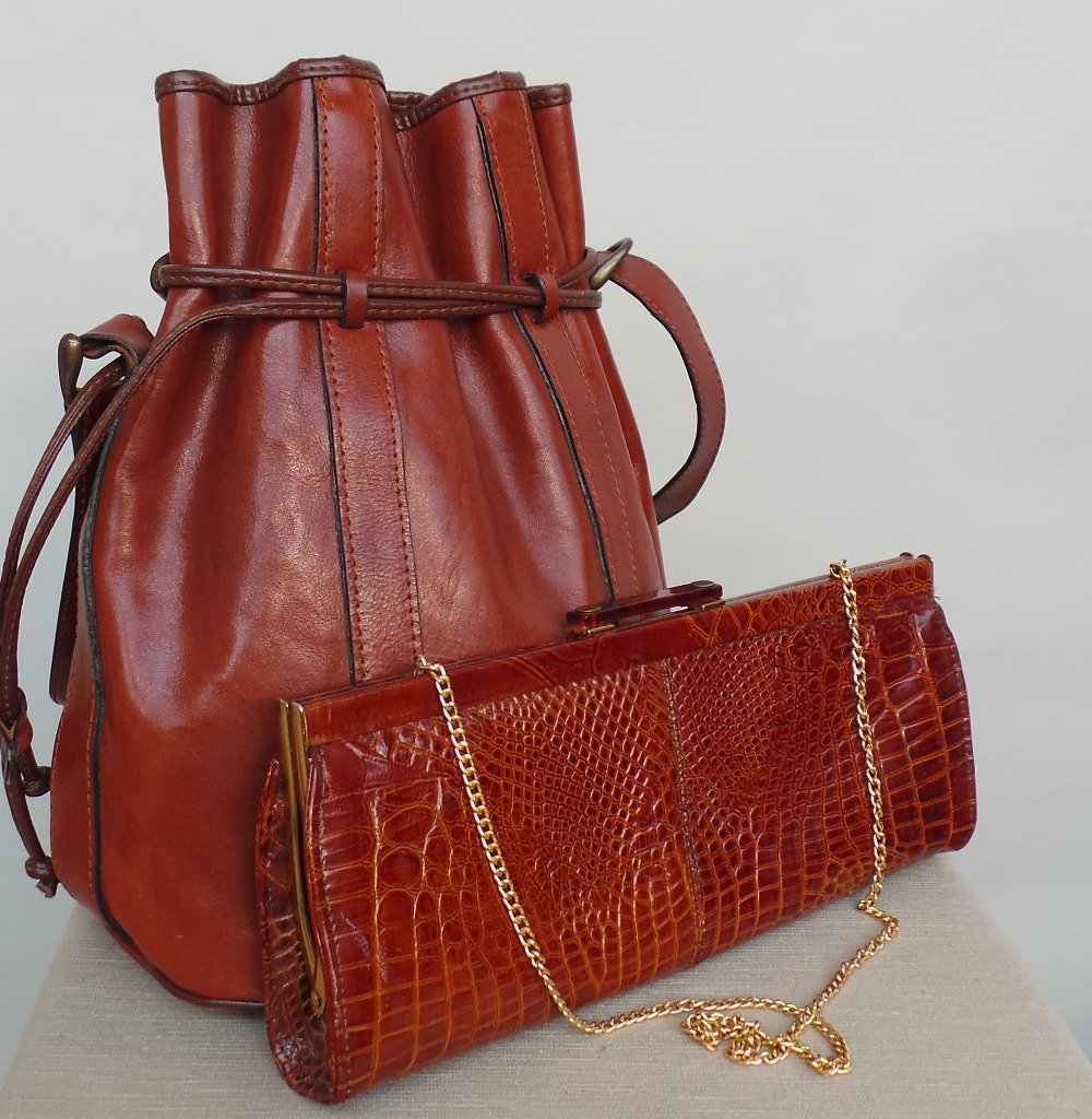 A very elegant 70's faux skin clutch bag with optional: A very elegant 70's faux skin clutch bag with optional gold chain strap. A further leather tote bag with drawstring top to close. Both bags in good condition. (2)