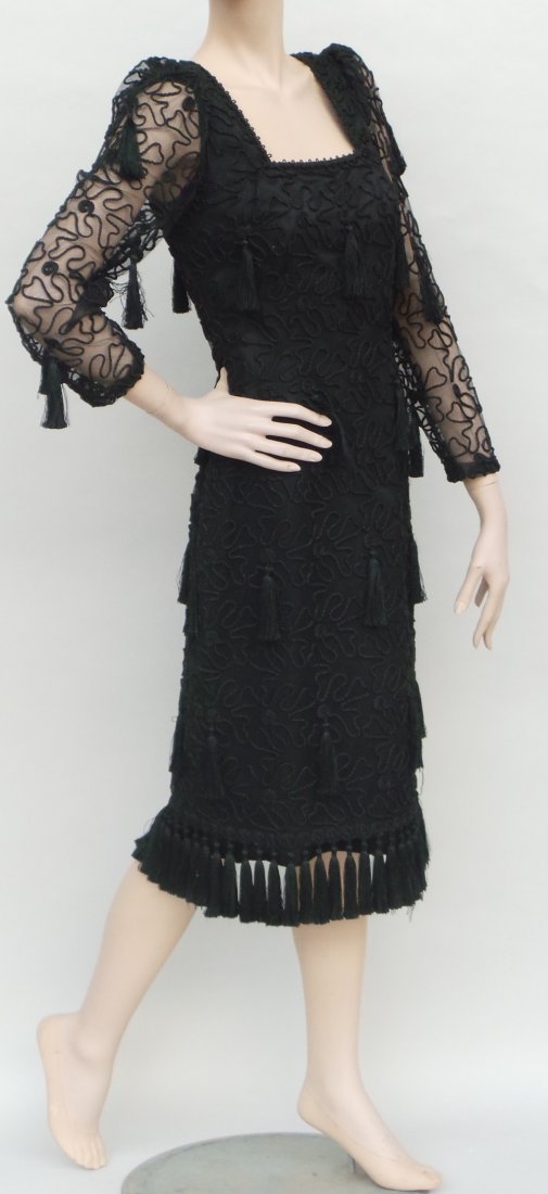 A stunning 1980's 'Louis Feraud' black dress. This: A stunning 1980's 'Louis Feraud' black dress. This garment in black sateen is overlayed with a heavily embellished viscose net and decorated all over with tassles which also frame the hem. The necklin