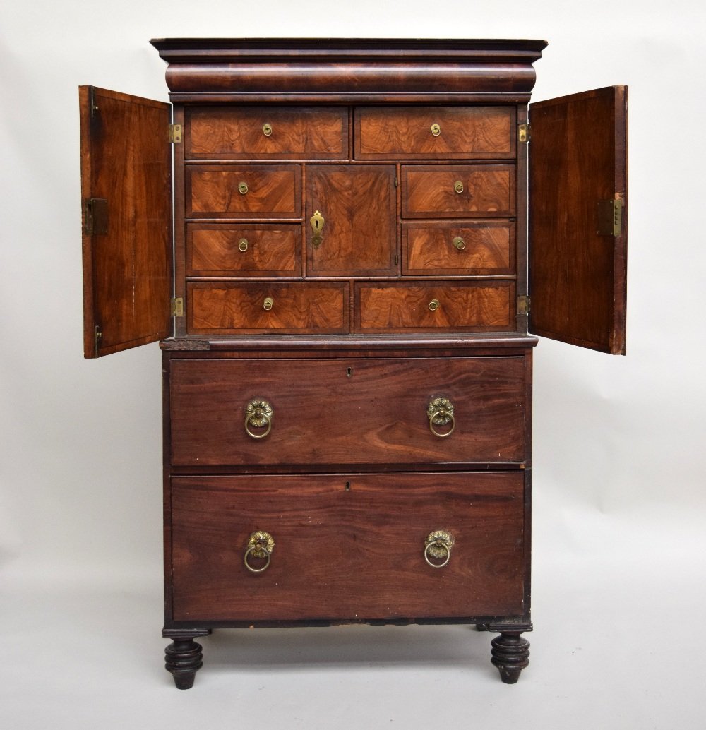 A William and Mary walnut cabinet on later chest,: A William and Mary walnut cabinet on later chest, cushion drawer above ebony strung doors revealing a fitted interior of cupboard and drawers, on a later mahogany two drawer base, on turned toupie fee