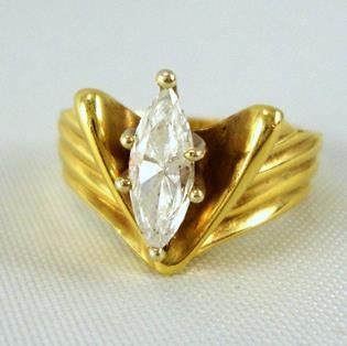 18 Kt. Diamond Ring: Unusual cut on this navette shaped diamond set in an 18 karat yellow gold setting. Little balls in the inside of the shank help to keep the ring stable on your finger. Tiny size is no doubt meant for 