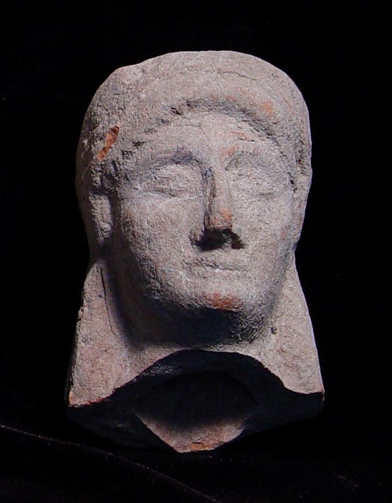 ARCHAIC GREEK VOTIVE TERRA COTTA GODDESS: ARCHAIC GREEK VOTIVE TERRA COTTA GODDESS. c. 4th century BC. The Korai style figure with long braided hair and wearing a polos on her head. 2 x 2.5 inches. Good example with good detail (better than i