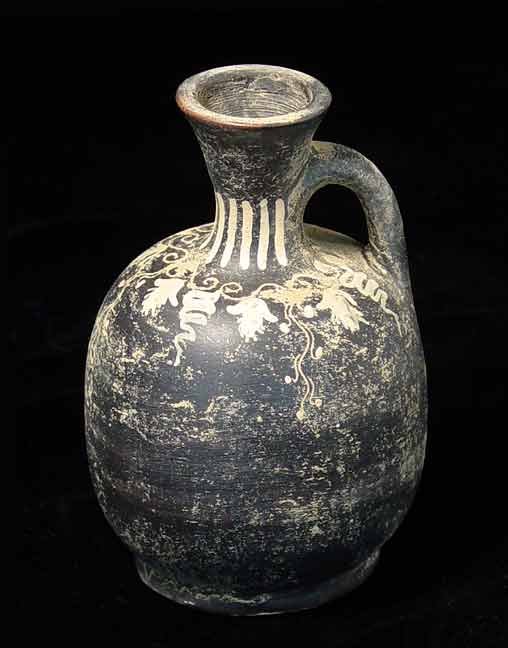 GREEK GNATHIAN WARE BLACK GLAZED BOTTLE: GNATHIAN WARE BLACK GLAZED BOTTLE, Greeks in South Italy, c. 4th century BC. Grape vines in pale yellow on black glazed body. Light deposits. 3.25 x 5 inches. Provenance: An extensive 20th century New