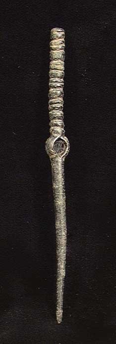 BETTER SYRIAN BRONZE CLOAK PIN: BETTER SYRIAN BRONZE CLOAK PIN. ca. 1st millennium BC. The cloak pin with central attachment hole and ribbed head. 4 inches. These pins were used to fasten and ornament garments and also doubled as we