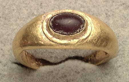 ROMAN GOLD RING WITH CABOCHON GARNET SETTING: ROMAN GOLD RING WITH CABOCHON GARNET SETTING, ca. 1st-3rd century AD. The band of hollow sheet gold over frit, a cabachon garnet set in the bezel. 23 mm, 16 x 18 mm internal. US size 6.6.Provenance: A