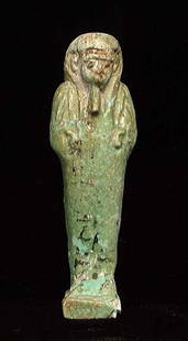 EGYPTIAN FAIENCE U'SHABTI, 26th Dynasty,: AN EGYPTIAN FAIENCE U'SHABTI, 26th Dynasty, 664-525 BC. The protective figure of pale green to sand color with traces of black painted hieroglyphics from the Book of The Dead. ~3.75".Provenance: The c