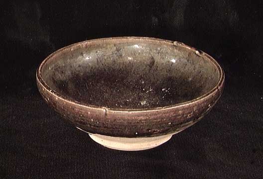 EARLY THAI BROWN GLAZED BOWL: AN EARLY THAI BROWN GLAZED BOWL, ca. 1st millennium AD. The small footed bowl with brown glaze over interior and coming down over the exterior till just above the base. 1.5 x 4 inches. Excellent condi