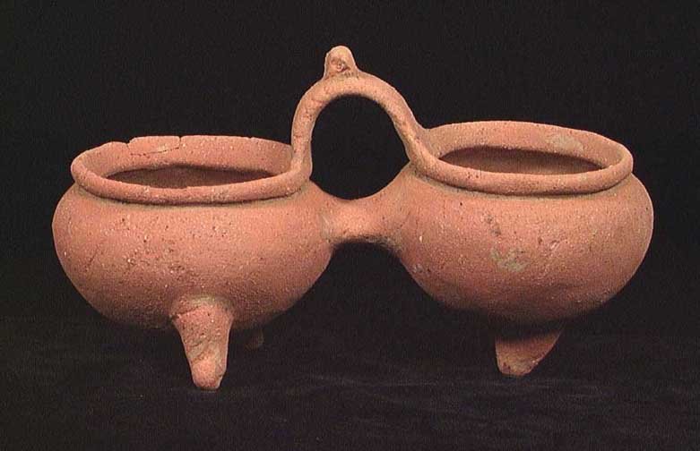SCARCE CHIRIQUI DOUBLE CHAMBERED TRIPOD.: SCARCE CHIRIQUI DOUBLE CHAMBERED TRIPOD. Panama, Barilles, ca. 1200-1500 AD. The two chambers sharing the tripod legs and bridged by the handle. 8.5" wide. Provenance: An extensive East Coast Pre-Colu