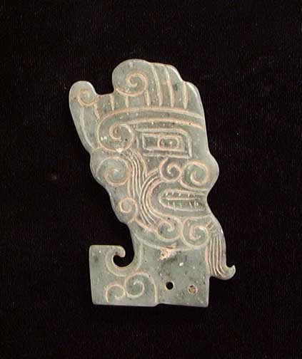 PUBLISHED MING DYNASTY OR EARLIER JADE: PUBLISHED IN 'ORIENTAL ANTIQUES AND ART'. MING DYNASTY OR EARLIER JADE, ca. 1400-1600. Carved both sides with finely styled archaic head. 2.8". Published in "Oriental Antiques & Art, An Identification
