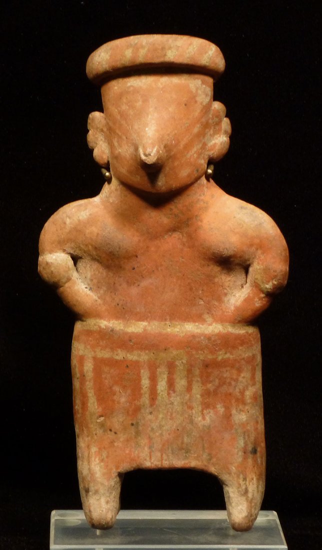 IMPOSING PRE-COLUMBIAN STANDING FIGURE: PRE-COLUMBIAN STANDING FIGURE. 7.5 x 4 inches. Orange, red and white glazed figure wearing short skirt and headdress. On custom stand. Provenance: A New Jersey collection bought at auction in Manhatta