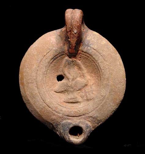 THE ABDUCTION OF GANYMEDE BY ZEUS: ROMAN OIL LAMP DEPICTING THE YOUTH GANYMEDE BEING CARRIED AWAY BY ZEUS IN THE GUISE OF AN EAGLE, c. 1st-2nd century AD. The clay oil lamp with the beautiful youth Ganymede being abducted by Zeus who h