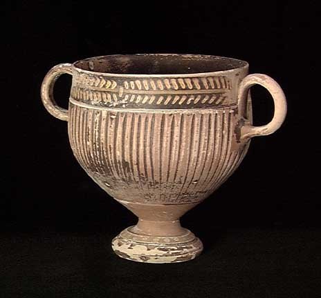 ELEGANT GNATHIAN GREEK SKYPHOS: ELEGANT GNATHIAN GREEK SKYPHOS, ca. 4th century BC. The elegant cup on pedestal base with twin vertical ring handles and fluted sides, the rim and base with yellow and black designs. 3.6 x 5.25 inches