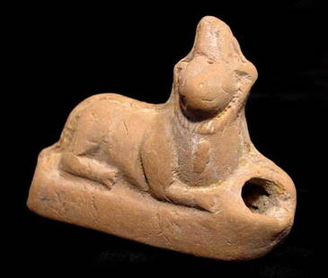 EGYPTIAN SEKMET LION GODDESS: EGYPTIAN TERRA COTTA FIGURE OF SEKMET. Egypt, Ptolemaic Period, c. 3rd-1st century BC. The lion goddess reclining right with ureaus crown and ornamented collar. 2.25 x 2.75 inches. The hole between he