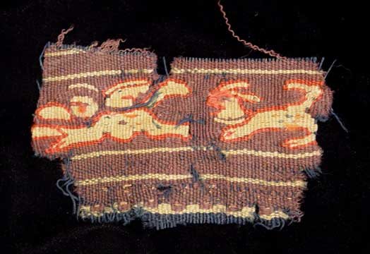 COLORFUL COPTIC TEXTILE FRAGMENT: COLORFUL COPTIC TEXTILE FRAGMENT. EGYPT, c. 4th-6th century AD. The double weave fragment depicting a winged Christian angel followed by a canine. 2.5 x 4 inches.