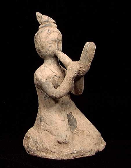 PUBLISHED IN 'ORIENTAL ANTIQUES AND ART': HAN DYNASTY MUSICIAN, 207 BC - 220 AD. The figure kneeling and playing a long upturned pipe. 7.5 inches. Published in "Oriental Antiques & Art, An Identification and Price Guide, 2nd Edition" by Mark 