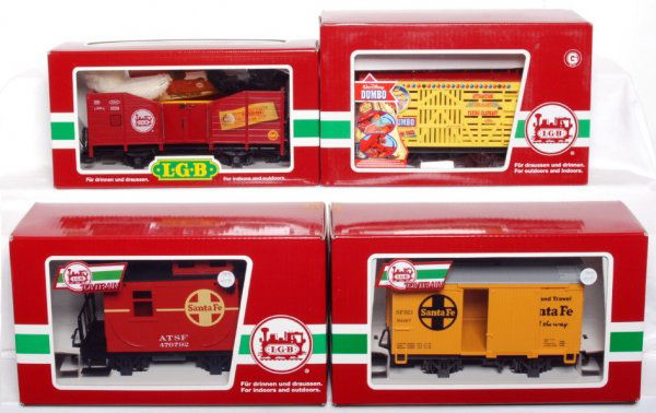 Four LGB G scale freight cars in original boxes: LGB G scale 41220 gondola with two Steiff Bears, 94168 Dumbo stock car, 94467 Santa Fe boxcar and 94465 Santa Fe bobber caboose in original boxes, C8-10. Boxes have a price sticker.
