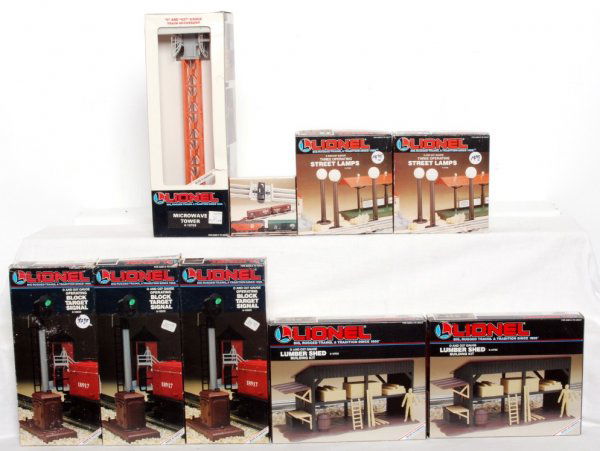 Lionel accessories in original boxes: Lionel 12743 O gauge track clips, two 12708 three operating street lamps, three 12832 operating block target signals, two 12705 lumber sheds and 12723 microwave tower. Accessories look C8-9. Boxes sho