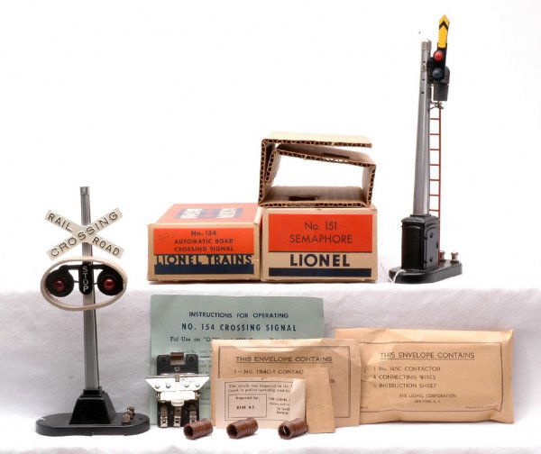 Lionel 151 Semaphore 154 Crossing Signal MINT OBs: Lionel postwar 151 semaphore in OB with original cardboard insert and factory sealed packet. Also included is a 154 automatic road crossing signal with a die cast cross arm in OB with cardboard ring,