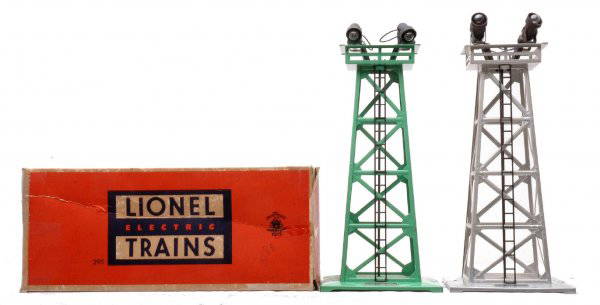 Lionel 395 Green OB 395 Aluminum Floodlights LN: Lionel postwar two 395 floodlight towers, one green in worn OB and one aluminum. The towers are C7-8.