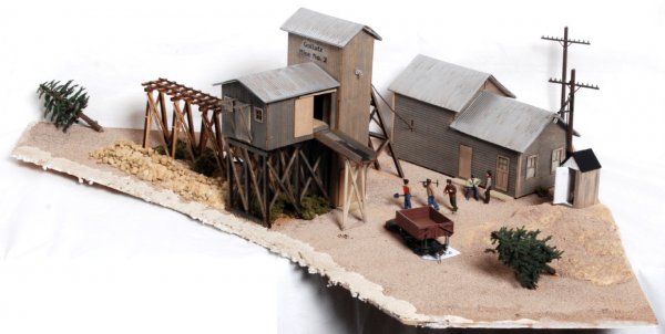 Mine shaft head/mining camp diorama/scene: Mine shaft head/mining camp diorama/scene that was mounted and used on an operating and functional O gauge layout. This is constructed of 3/4 inch particle board with a 1X4 framing. Wiring under neath