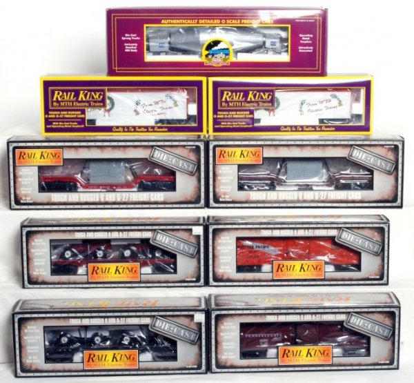Nine MTH Rail King freight cars in original boxes: Nine MTH Rail King O gauge freight cars in original boxes, C9-10. Boxes show little to very light wear. Two MT-7805 holiday reefers. Six die cast cars, 30-8301 Santa Fe depressed flat w/transformer, 3