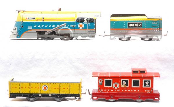 Hafner Trains Litho 115041 90131 91746 41021: Hafner Trains lithographed freight set including; 115041 clockwork loco, 90131 tender, 91746 gondola and a 41021 caboose. The tender has one side which is dented in. The couplers have surface rust. Se